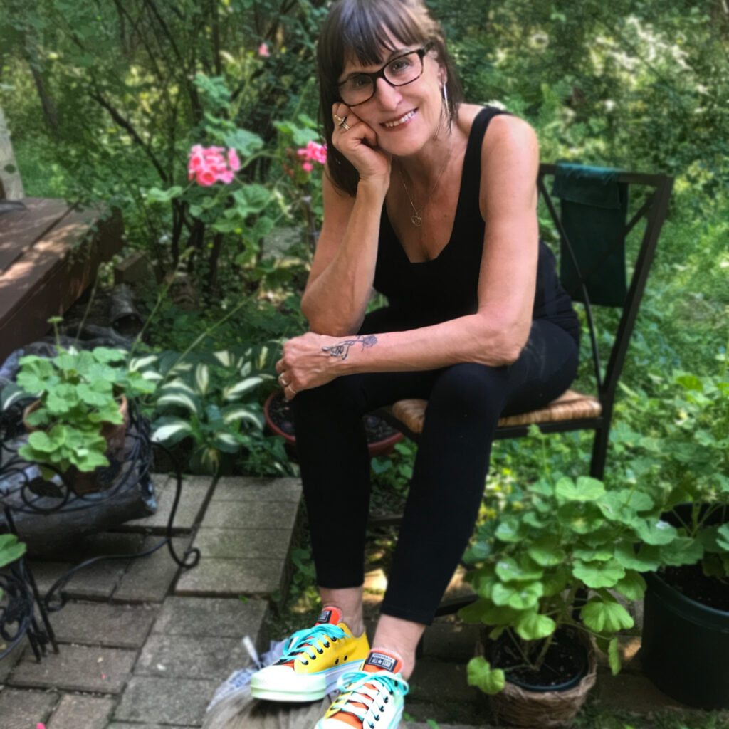 Photo of Lucy Lamp wearing custom colorful converse shoes