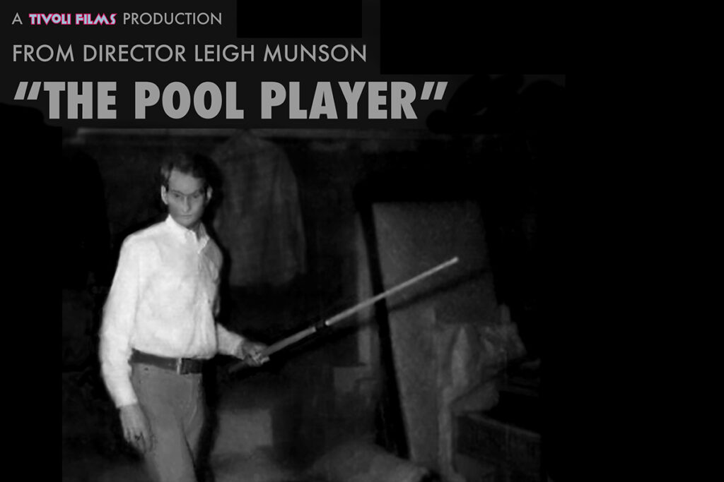 Black and White photo of young man in button down white shirt holding a pool stick.
