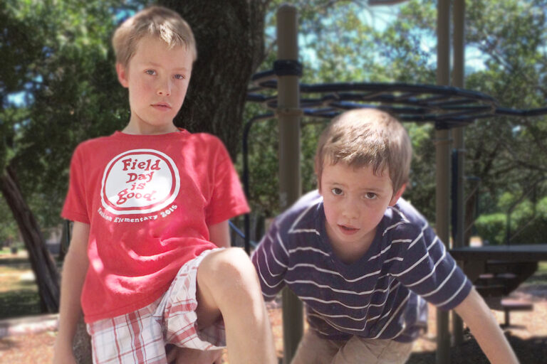 Two young boys in a park on a summer day.